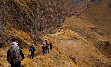 Hikers traverse a rugged path in the Andes mountains