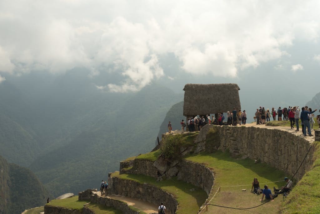 Tourists enjoying the scenic views from Machu Picchu's ancient terraces in Cusco, Peru.