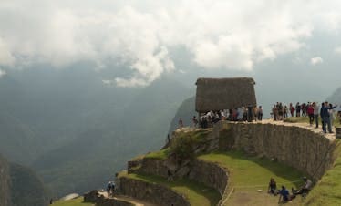 Tourists enjoying the scenic views from Machu Picchu's ancient terraces in Cusco, Peru.