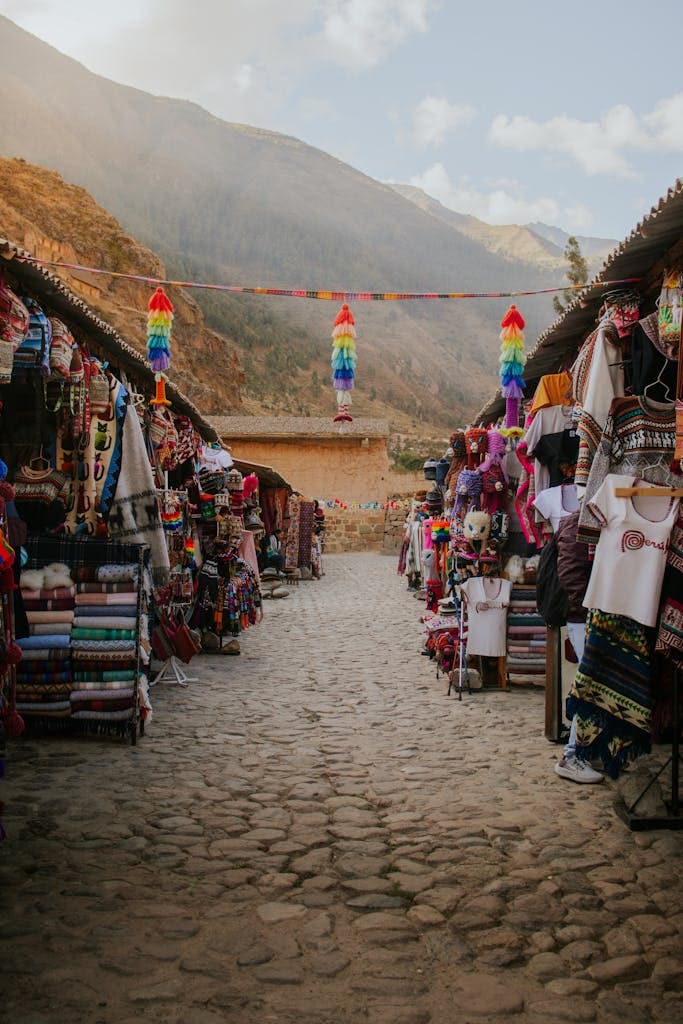 Colorful street market against mountain backdrop in Ollantaytambo, Peru.